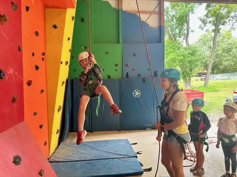 Kids helping each other while rock climbing