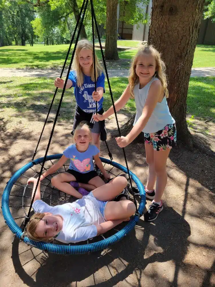 Kids smiling while using a circular hammock
